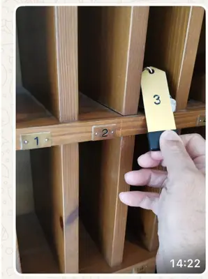 a person holding a piece of paper on a shelf at Gianni's Home2 Santa Cristina VG in Santa Cristina in Val Gardena