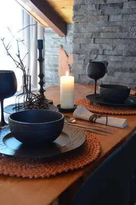 a table with two bowls and a candle on it at Mountain Suite with tub and view, Alpine design in Sanzeno