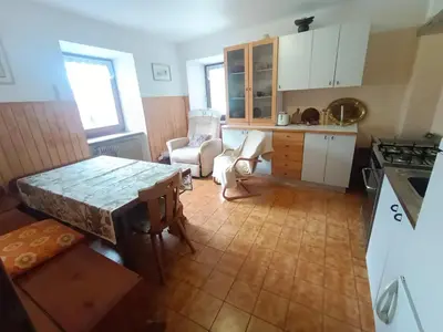 a kitchen with a table and chairs in a room at Stella Alpina in Romeno