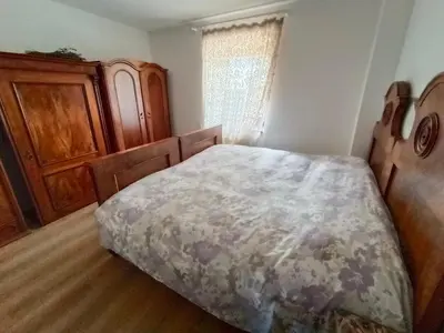 a bedroom with a bed and a wooden cabinet at Stella Alpina in Romeno