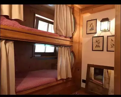 a bedroom with two bunk beds in a house at Cottage Cortina d Ampezzo in Cortina dʼAmpezzo