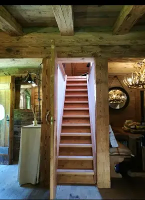 a stairway leading to a room with wooden ceilings at Cottage Cortina d Ampezzo in Cortina dʼAmpezzo