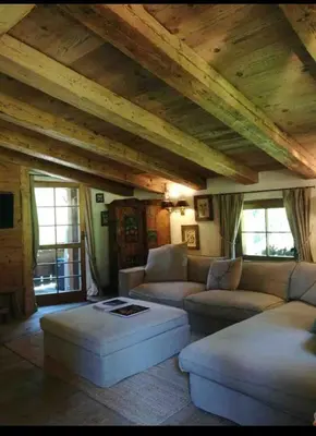 a living room with couches and a wooden ceiling at Cottage Cortina d Ampezzo in Cortina dʼAmpezzo