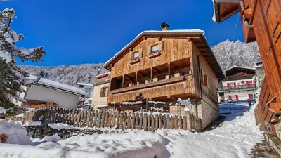a wooden house in the snow with a fence at Tabia del Caser in San Tomaso