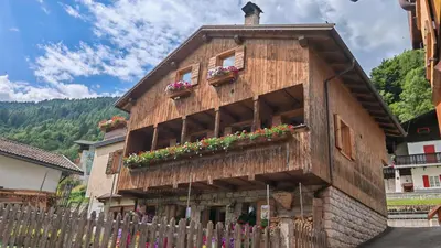 a wooden building with flower boxes on it at Tabia del Caser in San Tomaso