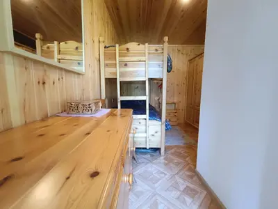 a room with bunk beds and a wooden floor at Coldemies apartment in Alleghe