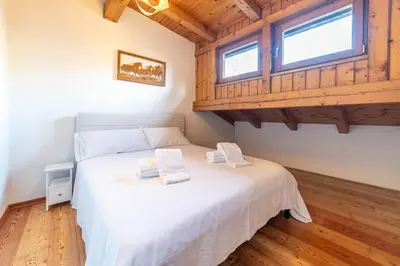a bedroom with a large bed and a mirror at Altèra Home in Rocca Pietore