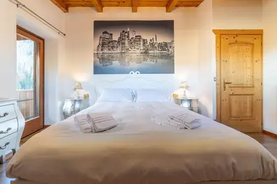 a bedroom with a large white bed with two pillows at Altèra Home in Rocca Pietore