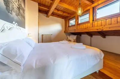 a bedroom with a white bed with two towels on it at Altèra Home in Rocca Pietore