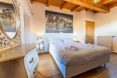 a bedroom with a large white bed and a mirror at Altèra Home in Rocca Pietore