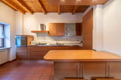 a kitchen with wooden cabinets and a wooden counter top at Altèra Home in Rocca Pietore