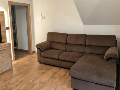 a living room with a brown couch and a ottoman at Appartamento Anna in Campestrin