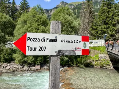 a sign on a wooden post next to a river at Appartamento Anna in Campestrin