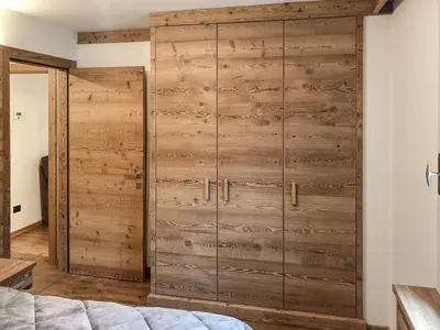 a wooden sliding door in a bedroom with a bed at Appartamento Anna in Campestrin