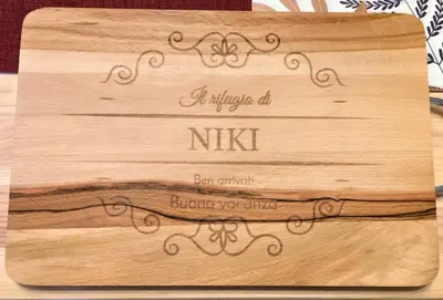 a wooden cutting board with a sign on it at Rifugio di Niki in Falcade