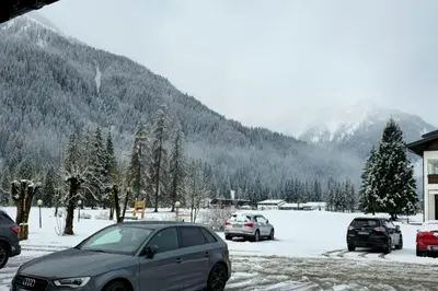 a car parked in a parking lot in the snow at Rifugio di Niki in Falcade