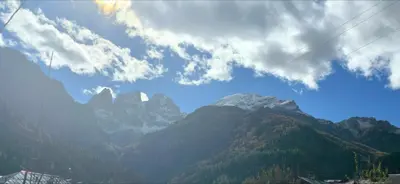 a view of a mountain range with clouds in the sky at Rifugio di Niki in Falcade