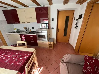a small kitchen with a couch and a table in a room at Rifugio di Niki in Falcade