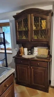 a large wooden cabinet in a kitchen at Casa Cecilia Dolomiti - scenic views, pets welcome in Piaia