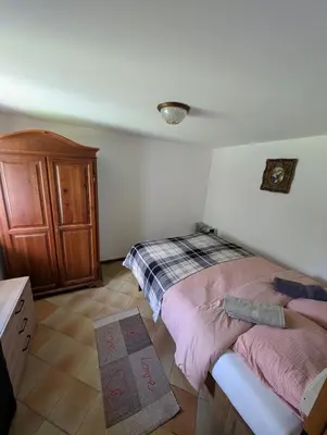 a bedroom with a bed and a wooden cabinet at Casa Cecilia Dolomiti - scenic views, pets welcome in Piaia