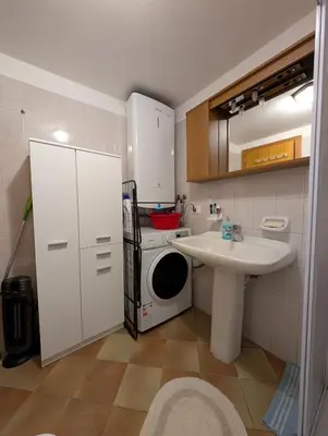 a small bathroom with a washing machine and a sink at Casa Cecilia Dolomiti - scenic views, pets welcome in Piaia