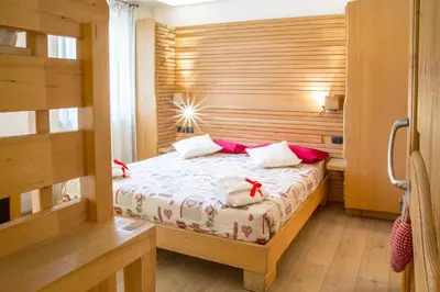 a bedroom with a bed with red bows on it at Agriturismo Pianrestel in Cavalese