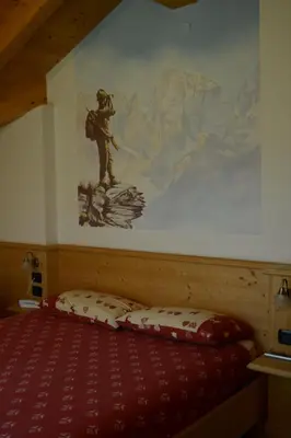 a bedroom with a large painting on the wall at Agriturismo Pianrestel in Cavalese
