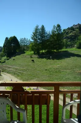 a view of a field from a deck with chairs at Agriturismo Pianrestel in Cavalese