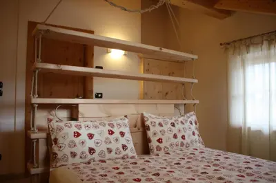 a bedroom with a bunk bed with red and white pillows at Agriturismo Pianrestel in Cavalese