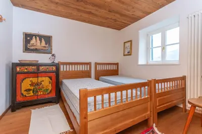 a bedroom with two beds and a table and a window at Casa Tamion in Vigo di Fassa