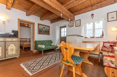 a living room with a wooden table and chairs at Casa Tamion in Vigo di Fassa