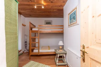 a small room with bunk beds and a table at Casa Tamion in Vigo di Fassa