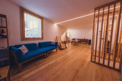 a living room with a blue couch and a table at Ciasa Nü - Piano Rialzato in Pozza di Fassa