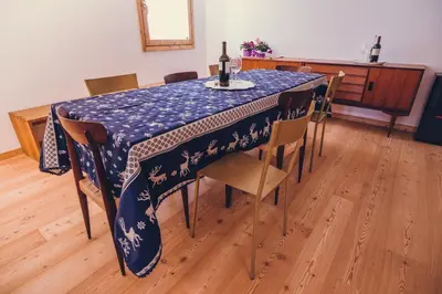 a dining room table with a blue tablecloth and chairs at Ciasa Nü - Piano Rialzato in Pozza di Fassa