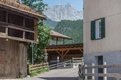 a building with a mountain in the background at Ciasa Nü - Piano Rialzato in Pozza di Fassa