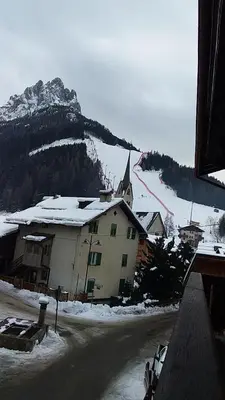 a snow covered mountain with a building and a church at Ciasa Nü - Piano Rialzato in Pozza di Fassa