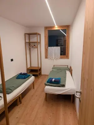 two beds in a small room with a mirror at Sella Ronda dalla Val di Fassa - CiasaNu 1° Piano in Pozza di Fassa