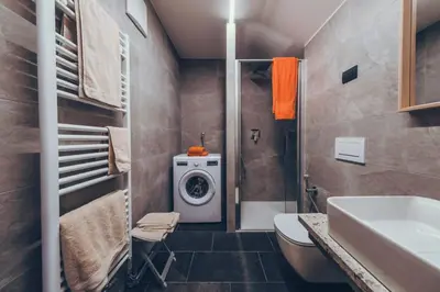 a bathroom with a washing machine and a sink at Sella Ronda dalla Val di Fassa - CiasaNu 1° Piano in Pozza di Fassa