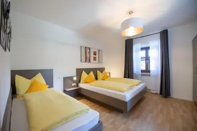 a bedroom with two beds with yellow pillows at Ferienwohnung Zum Bachanger in Termeno