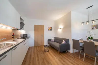 a kitchen and living room with a couch and a table at Ferienwohnung Zum Bachanger in Termeno