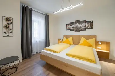 a bedroom with a large bed with yellow pillows at Ferienwohnung Zum Bachanger in Termeno