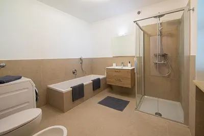 a bathroom with a shower and a toilet and a sink at Ferienwohnung Zum Bachanger in Termeno