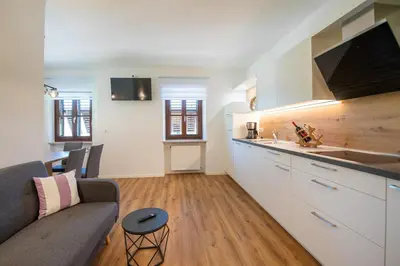 a kitchen and living room with a couch and a table at Ferienwohnung Zum Bachanger in Termeno