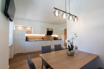 a kitchen and dining room with a table and chairs at Ferienwohnung Zum Bachanger in Termeno