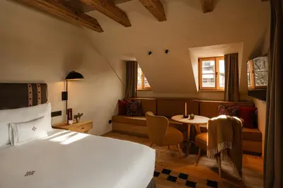 a hotel room with a bed and a table at Castel Badia - The Leading Hotels of the World in San Lorenzo di Sebato
