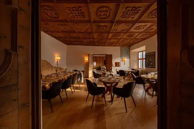 a dining room with tables and chairs and a ceiling at Castel Badia - The Leading Hotels of the World in San Lorenzo di Sebato
