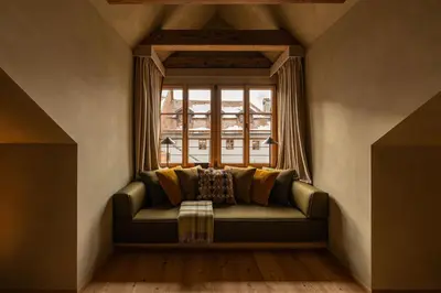 a couch in a room with a window at Castel Badia - The Leading Hotels of the World in San Lorenzo di Sebato