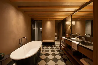 a bathroom with a bath tub and two sinks at Castel Badia - The Leading Hotels of the World in San Lorenzo di Sebato