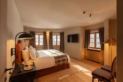 a hotel room with a bed and a desk at Castel Badia - The Leading Hotels of the World in San Lorenzo di Sebato