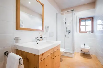 a white bathroom with a sink and a shower at Dependance Hotel Mareo Dolomites in San Vigilio Di Marebbe